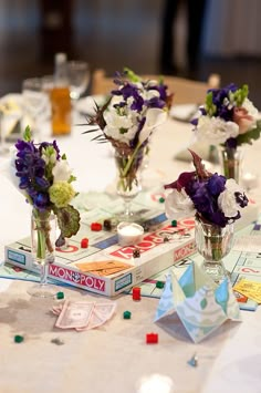 three vases filled with flowers sitting on top of a table