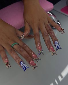 two hands with different designs on them and one has pink, white and blue nail polish