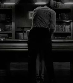 a man standing in front of a bookshelf filled with lots of book shelves