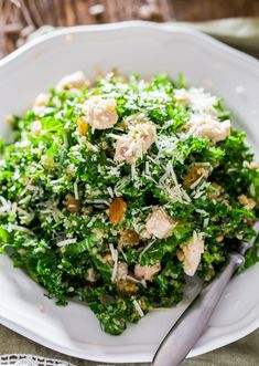 a white plate topped with broccoli covered in parmesan cheese and nuts