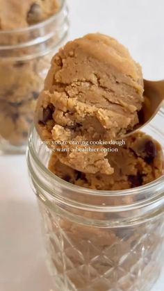 an ice cream scooping out of a jar filled with cookies and raisins