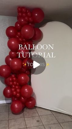 the balloon arch is made out of red balloons and has been placed in front of a white wall