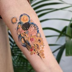 a woman's arm with an artistic tattoo on it