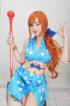 a woman with red hair and blue dress holding a baseball bat in her right hand