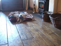 a dog laying on the floor in front of a fire place with blankets around it