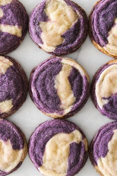 purple and white cookies with icing on them are arranged in a square pattern,