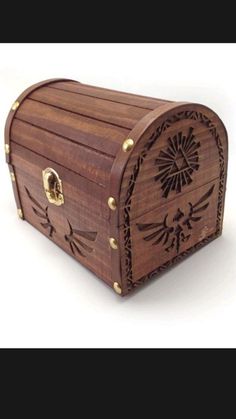 a wooden box with an intricate design on the front and sides, sitting on a white surface