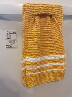 a yellow and white towel hanging on the side of a refrigerator