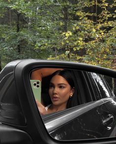 a woman is taking a selfie in the mirror of a car with her phone