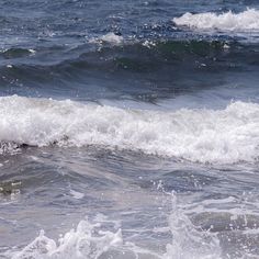 an ocean wave is breaking on the beach