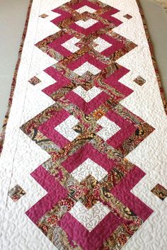 a pink and white quilted table runner