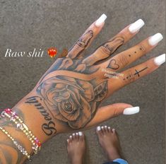 two hands with tattoos and white nails on them