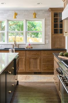 a large kitchen with wooden cabinets and stainless steel appliances, along with marble counter tops