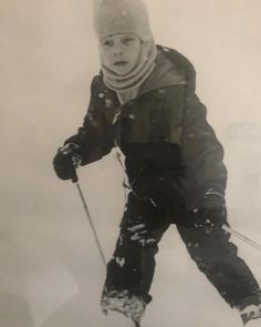 a young boy riding skis down a snow covered slope