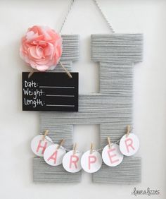 a sign that says happy hanging on a wall with clothes pins and a pink flower