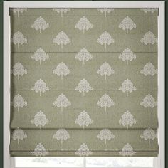 a window with a green and white patterned roman blind