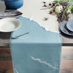 the table is set with plates and silverware, along with a blue potted plant