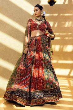 Multicolor lehenga with contrast panels and printed motifs. Paired with V-back blouse with bead tassel tie-up. Comes with a green dupatta.
Component: 3
Pattern: Printed
Type Of Work: Floral motifs, Geometric
Neckline: Leaf neck
Sleeve Type: Half sleeves
Fabric: Blouse and lehenga skirt: Natural silk, Dupatta: Soft net
Color: Multi Color
Other Details: 
Printed motifs
Contrast panels
Tassel tie-up back
Note: The neckpieces worn by the model and bag shown in the image are not for sale.
Occasion: W Printed Lehenga, Wedding Lehenga Designs, Lehenga Blouse Designs, Lehenga Style, Lehenga Skirt, Multi Color Blouse, Bridal Lehengas, Lehenga Blouse, Wedding Dresses For Girls