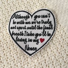 a heart shaped embroidered patch with words on it