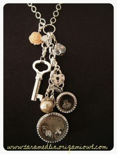 a close up of a necklace on a black surface with charms and keys attached to it