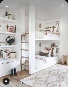 a bedroom with white walls and shelves filled with books, plants and other things on top of it