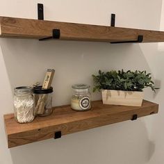 two wooden shelves with plants and jars on them