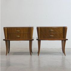 two wooden nightstands sitting next to each other on top of a white flooring