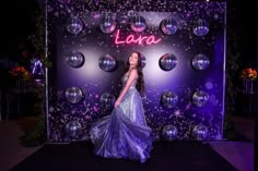 a woman standing in front of a backdrop with disco balls