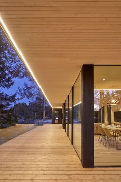 an outdoor dining area with wooden flooring and large glass doors leading to the outside