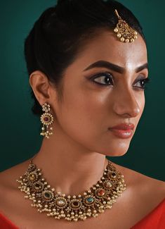 Embrace the rich cultural heritage and timeless beauty that this stunning Antique Multi Stone Necklace Set embodies. Each piece is thoughtfully crafted to highlight a vibrant collection of nine precious gemstones, symbolizing the celestial navrattan, which is revered for its ability to foster prosperity and harmony. The necklace measures by 19 inches, and earrings by 5 inchesComposition : Mixed Metal with other Semi Precious StonesCare: Keep away from water and perfume Delivery : 2-4 weeks as the product is hand crafted. For more information and sizes please contact fabiliciousfashion@gmail.com or visit our Copenhagen studio. About the Designer : Zaza by Somya is a thoughtfully curated collection of bold yet feminine jewelry pieces. Her striking rings, bracelets, and necklace sets celebrat Fusion Style Jeweled Jewelry Sets As Gift, Fusion Jeweled Jewelry Sets For Gifts, Spiritual Round Necklaces For Festive Occasions, Festive Spiritual Round Necklace, Round Gemstone Temple Necklace For Festive Occasions, Ceremonial Multicolor Necklace With Intricate Design, Multicolor Necklace With Intricate Design For Ceremonial Occasions, Multi-stone Temple Jewelry Necklaces, Temple Jewelry Style Jeweled Necklace As Gift