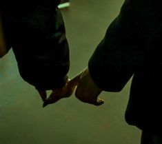 two people holding hands in the dark with their fingers touching each other's foreheads