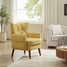 a living room filled with furniture and a window covered in white curtained drapes