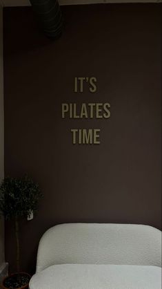 there is a white bed in the room with it's pilates time written on the wall