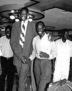 a group of men standing next to each other in front of suitcases and luggage