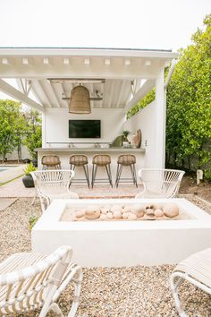 an outdoor living area with chairs and a fire pit