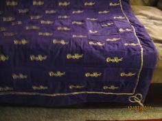 a purple blanket sitting on top of a bed