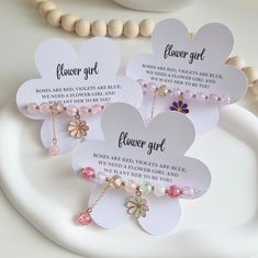 three flower girl necklaces on a white plate