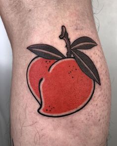 a red apple tattoo on the side of a man's leg with black ink