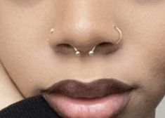 a close up of a person with nose piercings on their forehead and lip ring