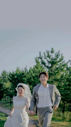 a bride and groom are walking down the road