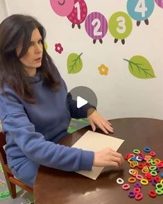 a woman sitting at a table with lots of magnets on it's surface