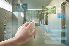 a hand is touching the glass on top of a wall with photos and video clips