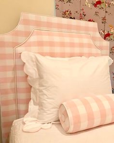 a pink and white checkered headboard with two pillows on the bottom, and one pillow in the middle