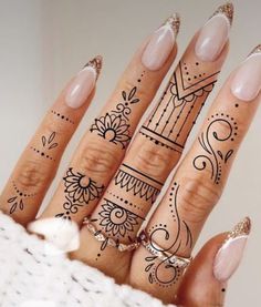 a woman's hand with henna tattoos on it