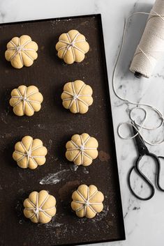 the doughnuts are ready to be baked on the baking sheet with scissors and twine