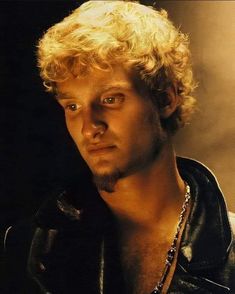 a man with blonde hair wearing a leather jacket