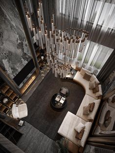 an aerial view of a living room with couches, tables and chandelier