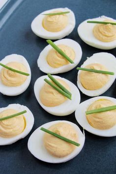 hard boiled eggs with chives on a blue platter, ready to be eaten