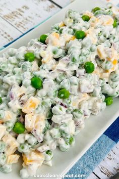 a white plate topped with pasta and peas