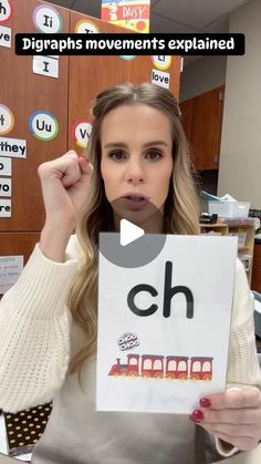 a woman holding up a sign with the word ch on it in front of her face